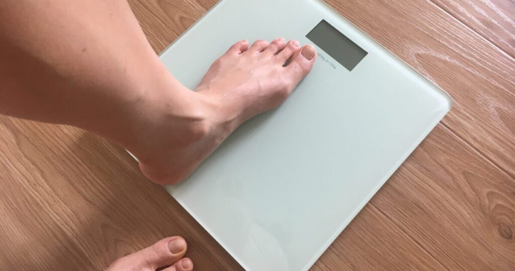 ガラス製デジタル体重計に足を乗せる瞬間