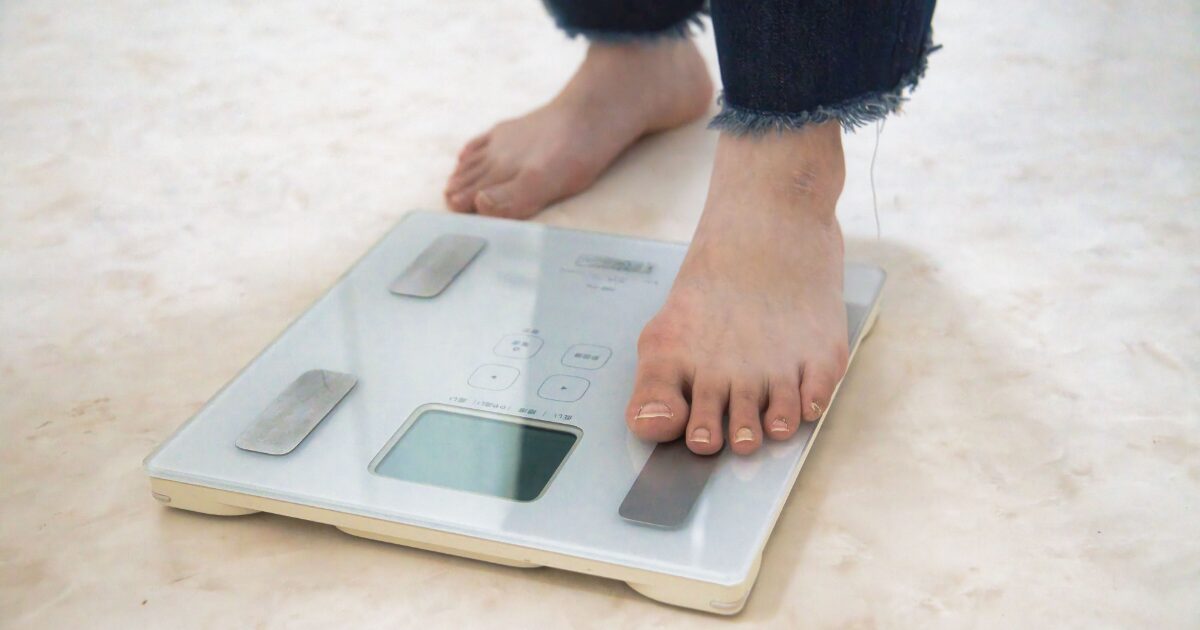 ガラス製体組成計に乗って測定を始める様子
